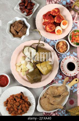 Menu Ketupat Lebaran con vari piatti laterali, piatto tradizionale celebrativo di torta di riso, popolare servito durante le celebrazioni Eid Top View Foto Stock