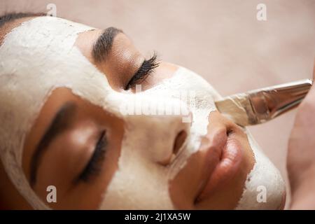 Nutrirsi la pelle. Scatto corto di una giovane donna che riceve un trattamento viso in una spa. Foto Stock