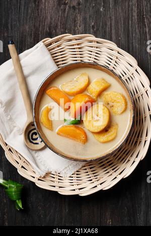 Top View Kolak o Kolak Pisang Ubi è un dessert indonesiano, popolare durante il Ramadhan, fatto da Banana e patate dolci cotte con latte di cocco, Palm su Foto Stock