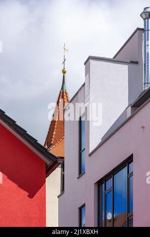 Chiesa storica campanile in contrasto con l'architettura moderna a Ebingen, Albstadt, Baden-Württemberg, Germania. Foto Stock