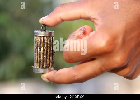 Filtro dell'olio con molti pezzi di metallo colpiti sulle superfici tenute in mano Foto Stock