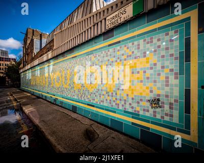 Sulla facciata della stazione originale della metropolitana Angel viene visualizzato il messaggio "Do what you love". Via Torrens. Londra. REGNO UNITO Foto Stock