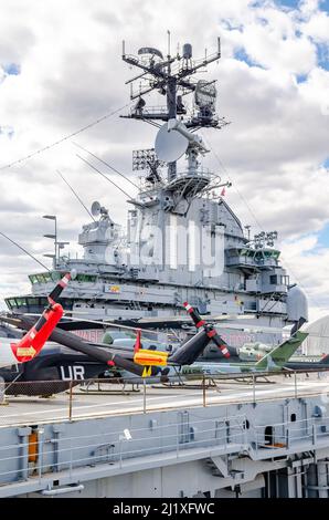 Torre dell'Intrepid con elicottero in piedi sul ponte dell'Intrepid Sea-Air-Space Museum, New York City durante la soleggiata giornata invernale, verticale Foto Stock