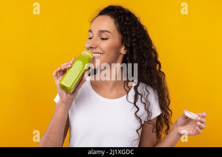 Ritratto di sorridente giovane signora bere Smoothie Foto Stock