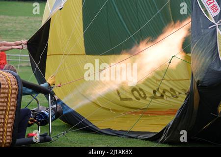 Un pallone ad aria calda che viene riempito con aria calda da un grande bruciatore a gas prima del volo. Foto Stock