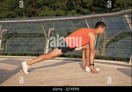 Sportivo tenere affondo posizione facendo stretching routine dopo outdoor atletica allenamento, stretching Foto Stock