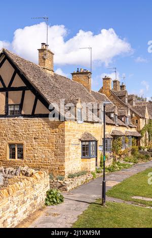 Una fila di vecchi cottage in pietra in High Street nel villaggio di Cotswold di Broadway, Worcestershire, Inghilterra Regno Unito Foto Stock