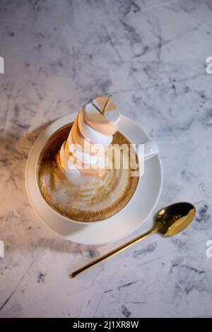 cappuccino con marmellata e cucchiaio d'oro sullo sfondo Foto Stock