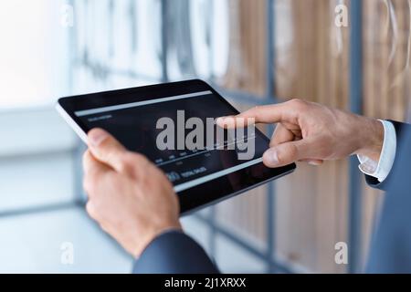 uomo d'affari che utilizza un tablet digitale per visualizzare i tassi di cambio della criptovaluta. primo piano. Foto Stock