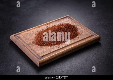 Tè Rooibos in una ciotola bianca su sfondo nero. Disposizione piatta, vista dall'alto, spazio di copia Foto Stock