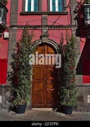 Bella vista frontale del vecchio edificio nel centro storico della città di Arucas a nord dell'isola di Gran Canaria, Isole Canarie, Spagna con porta di legno. Foto Stock