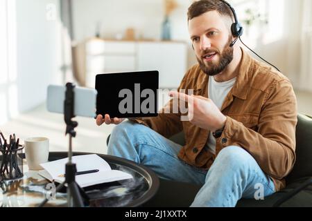 Videochiamata uomo che mostra la schermata Tablet per il telefono a casa Foto Stock