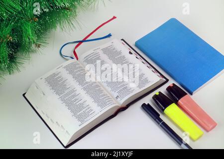 Studio foto interno della Bibbia Alkitab Open Blue notebook e cancelleria su sfondo bianco e Spruce Foto Stock