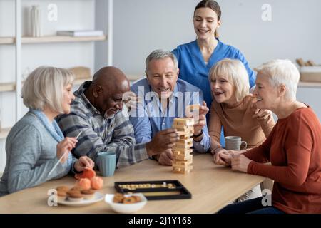 Felice gruppo multirazziale di pensionati che giocano a giochi da tavolo Foto Stock