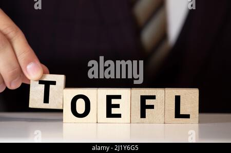 TOEFL - parole da blocchi di legno con lettere, il Test dell'inglese come lingua straniera, concetto TOEFL, sfondo bianco. Foto Stock