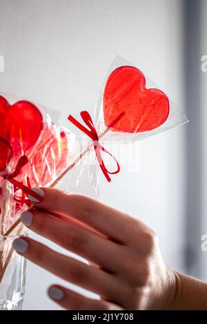 Lollipops rosso a forma di cuore sul bancone di un negozio di caramelle. Foto Stock