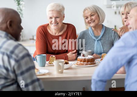 Amici anziani felici che bevono il tè con la torta insieme Foto Stock