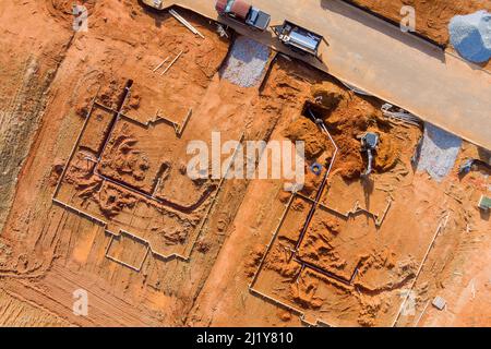 Posa di tubi nel terreno il terreno scavato durante i lavori di costruzione è predisposto per l'installazione di servizi sotterranei Foto Stock