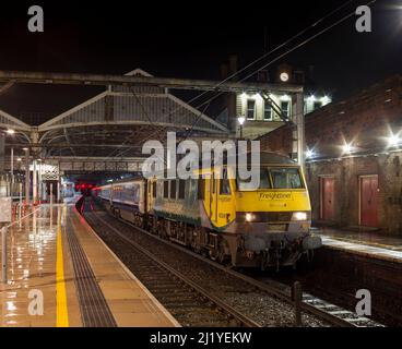 Il 2350 London Euston - Glasgow & Edinburgh Caledonian sleeper attende a Preston nelle prime ore trainati da un Freightliner classe 90 electric loco Foto Stock