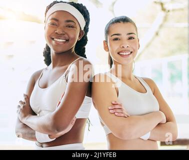 Quando si tratta di doppie, sono stati i migliori. Ritratto corto di due giovani e attraenti giocatori di tennis femminile in piedi con le braccia ripiegate in Foto Stock
