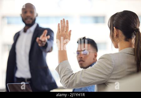 Theres qualcosa che vorrei accennare. Primo piano di una donna d'affari che alza la mano durante una riunione in un ufficio. Foto Stock
