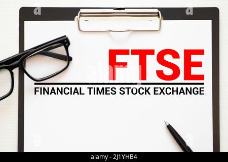 Mano sta girando un dado e cambia la direzione di una freccia che simboleggia che il FTSE Foto Stock