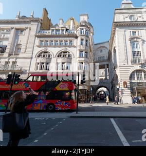 Londra, Greater London, Inghilterra, marzo 08 2022: Il turista scatta una foto su Regent Street guardando verso Air Street come un punto di vista che vede l'autobus passa vicino. Foto Stock