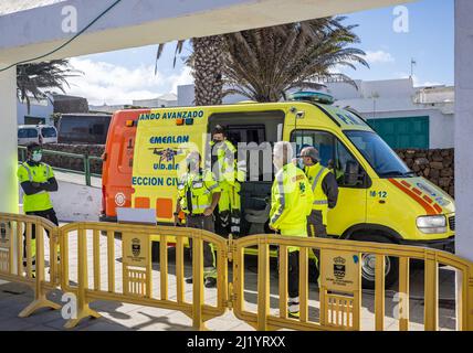 Gruppo di operatori dei servizi di emergenza in giacche ad alta visibilità in ambulanza al mercato domenicale Teguise a Lanzarote, Spagna, il 13 marzo 2022 Foto Stock