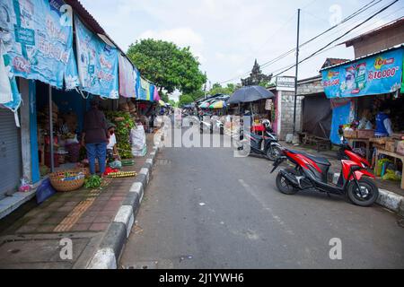 Una strada in Sukawati fiancheggiata da negozi che vendono prodotti locali, verdure ecc a Bali, Indonesia. Foto Stock