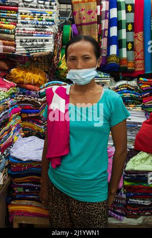 Una donna che vende sarong batik al mercato Pasar Seni Sukawati di Bali, Indonesia. Foto Stock