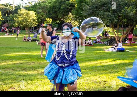 Goiânia, Goias, Brasile – 01 marzo 2022: Una ragazza che soffia enormi bolle di sapone. Foto scattata durante il Carnevale di strada in un parco pubblico della città. Foto Stock