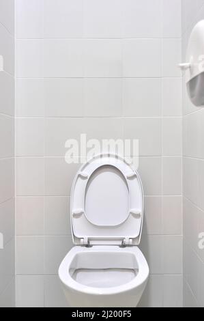 dettaglio di un gabinetto bianco con il coperchio aperto in un bagno pubblico Foto Stock