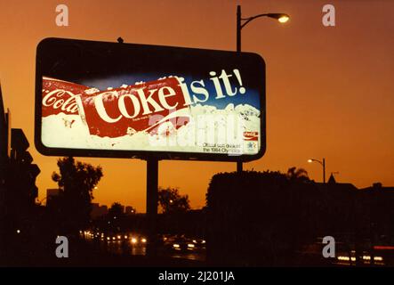 Un tabellone retroilluminato mostra un annuncio per Coca Cola è visto al tramonto di Los Angeles, CA circa 1984. Foto Stock