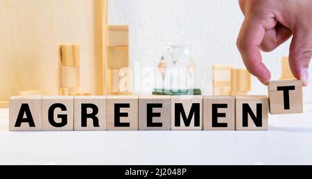 PAROLA DI ACCORDO su cubi di legno su sfondo grigio Foto Stock