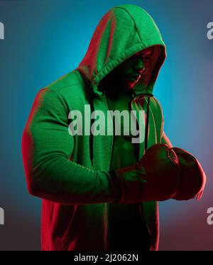 Im un amante non un combattente, ma io combatterò per quello che credo in. Scatto da studio di un giovane sportivo che indossa guanti da boxe. Foto Stock