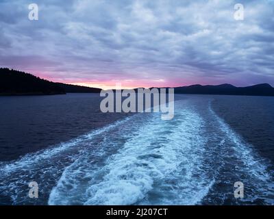 WA21209-00...WASHINGTON - Vista del tramonto dal traghetto che lascia l'Isola di San Juan e si dirige verso la terraferma ad Anacortes. Foto Stock
