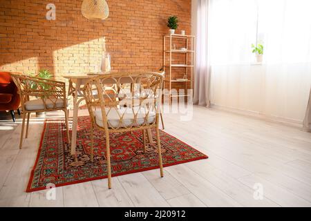 Interno di una moderna sala da pranzo con tavolo e tappeti vintage Foto Stock