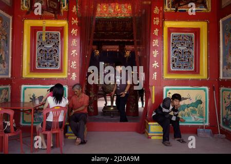 Persone all'ingresso di Chandra Nadi (Soei Goeat Kiong) tempio dedicato al buddismo, taoismo e confucianesimo a Palembang, Sud Sumatra, Indonesia. L'esistenza dell'attuale Chinatown a Palembang può essere tracciata solo fino all'epoca coloniale olandese, ma nel periodo Srivijaya (7th-11 secoli), il buddismo e le influenze cinesi nella zona erano già molto forti. 'Il re (Srivijaya), così come i governanti degli stati vicini favorirono il buddismo. La capitale era un centro di apprendimento buddista nelle isole del Mar Meridionale, e c'erano più di mille sacerdoti". Foto Stock