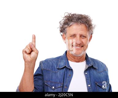 Dai un'occhiata qui. Studio ritratto di un uomo felice maturo che punta verso l'alto isolato su bianco. Foto Stock