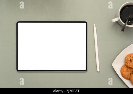 Vista dall'alto, Flat Lay, Workspace con schermo bianco per tablet digitale, penna stilo, una tazza di caffè e un piatto di biscotti su sfondo grigio. Foto Stock