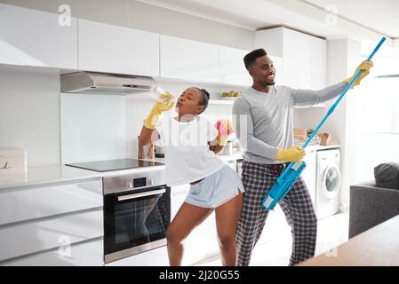 La differenza tra ordinario e straordinario è un po' in più. Scatto di una giovane coppia felice che si diverte mentre pulisce la cucina a casa. Foto Stock