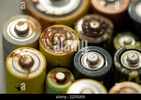 Primo piano della batteria usata con tracce di ruggine e corrosione. Concetto di rifiuti pericolosi elettronici Foto Stock