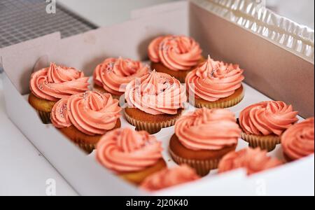 Questi sono pronti per essere consegnati. Shot di cupcake ritagliato in una scatola da asporto. Foto Stock