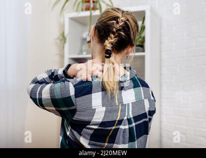 Giovane donna che soffre di dolore al collo. Giovane donna che le tiene il collo. Foto Stock