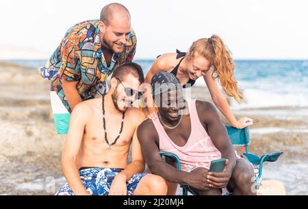 Gruppo di giovani sulla spiaggia prendendo un selfie. Foto Stock