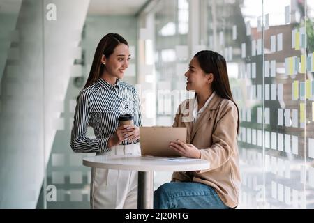 Gruppo di imprenditrice asiatica e contabile documento di controllo dati su carta rapporto grafico per l'indagine sul conto corruzione Foto Stock