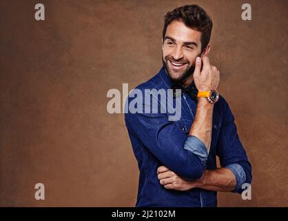 Vivi la vita con una risata. Studio girato di un giovane uomo vestito elegantemente. Foto Stock