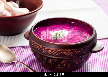 Holodnik - tradizionale zuppa di barbabietole fredde lituana (russo, ucraino, bielorusso, polacco) con cetriolo, uova bollite e verdure in ciotola rustica Foto Stock