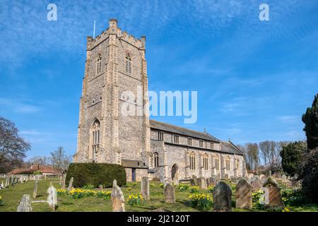 St James' Church a Castle Acre, Norfolk, con cieli blu e fiori primaverili nel cortile. Foto Stock