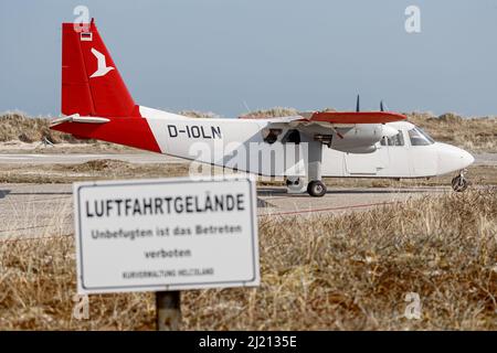 Helgoland, Germania. 25th Mar 2022. Un'Islander normanna Britten con nove posti a sedere dell'Ostfriesischer Flug-Dienst (OFD) si trova su una strada di taxi del campo aereo di Helgoland. Il nuovo collegamento aereo da Helgoland a Uetersen (distretto di Pinneberg) inizia venerdì 1 aprile. Gli aerei di Ostfriesischer Flug-Dienst (OFD) sono previsti per il decollo da Helgoland Dune il mercoledì alla domenica con due rotazioni al giorno, come annunciato dalla società a Emden. Credit: Markus Scholz/dpa/Alamy Live News Foto Stock